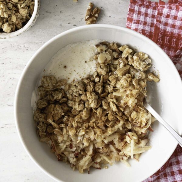Jogurto dubenėlis su obuoliu, granola, riešutais ir cinamonu.
