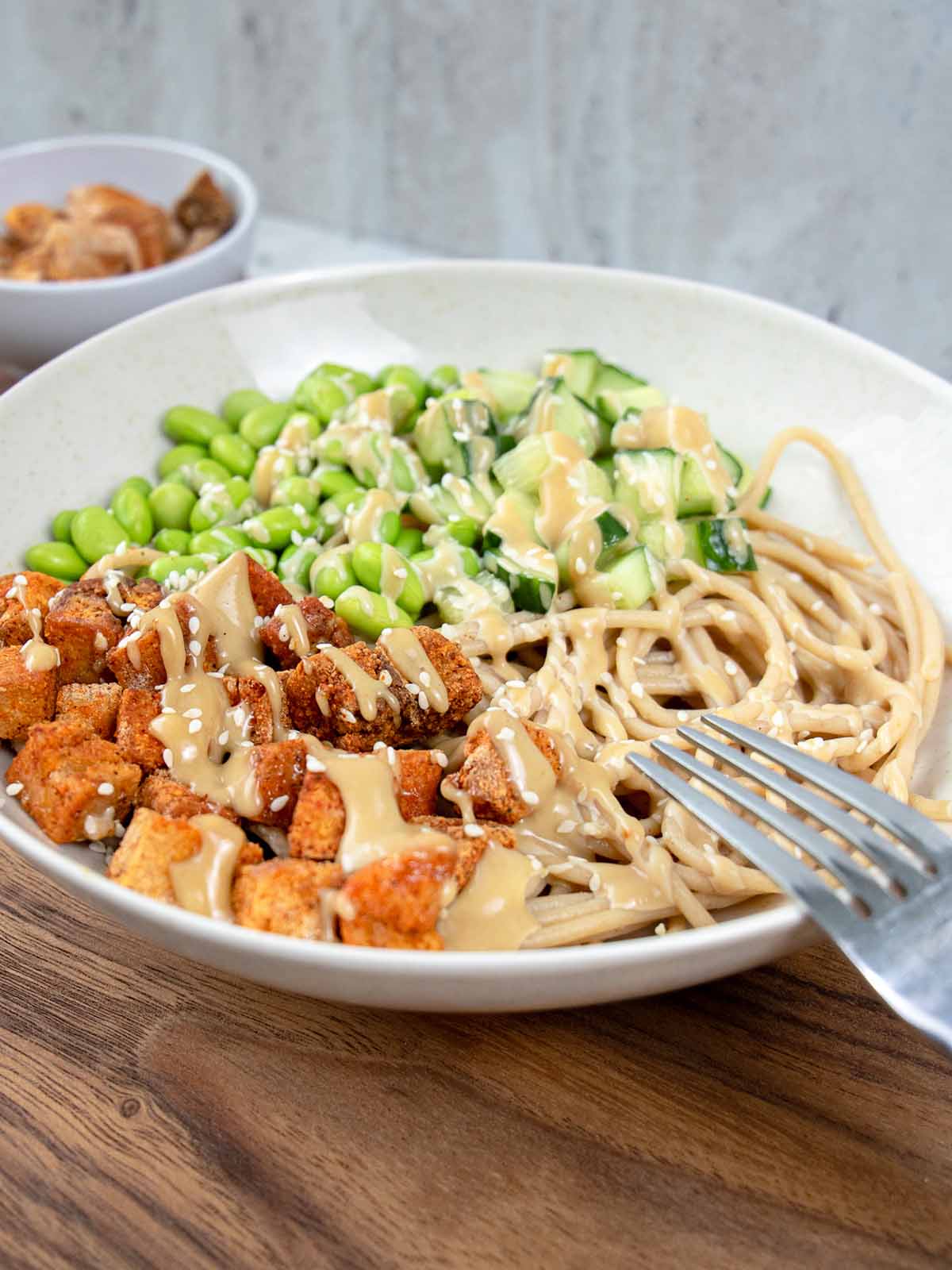 spageciai-su-padazu-v2 Spagečiai su riešutų sviesto padažu, tofu, edamame pupelėmis ir agurku.